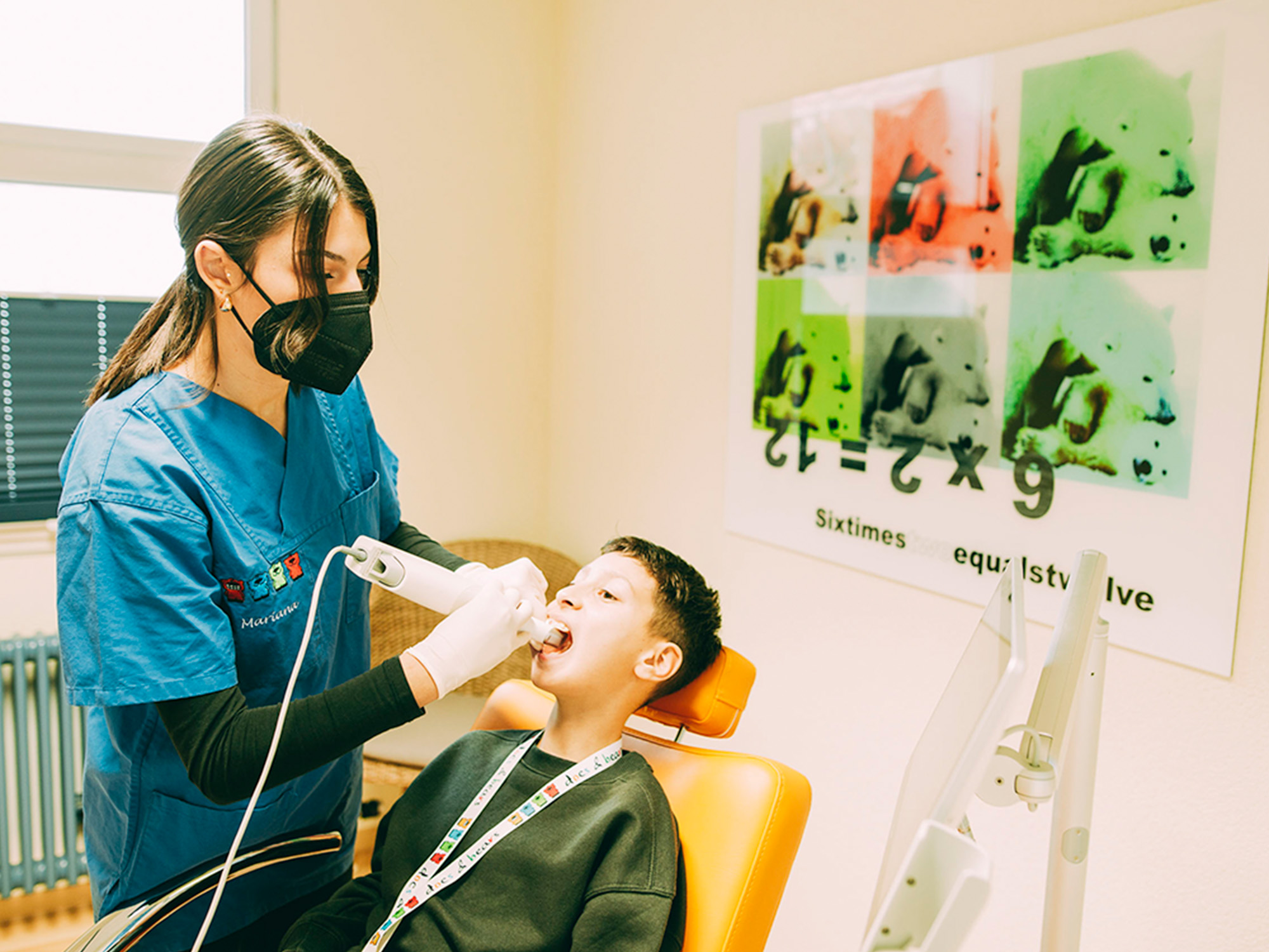 Mitarbeiterin untersucht Kind mit digitaler Röntgentechnik für präzise Kieferorthopädie.