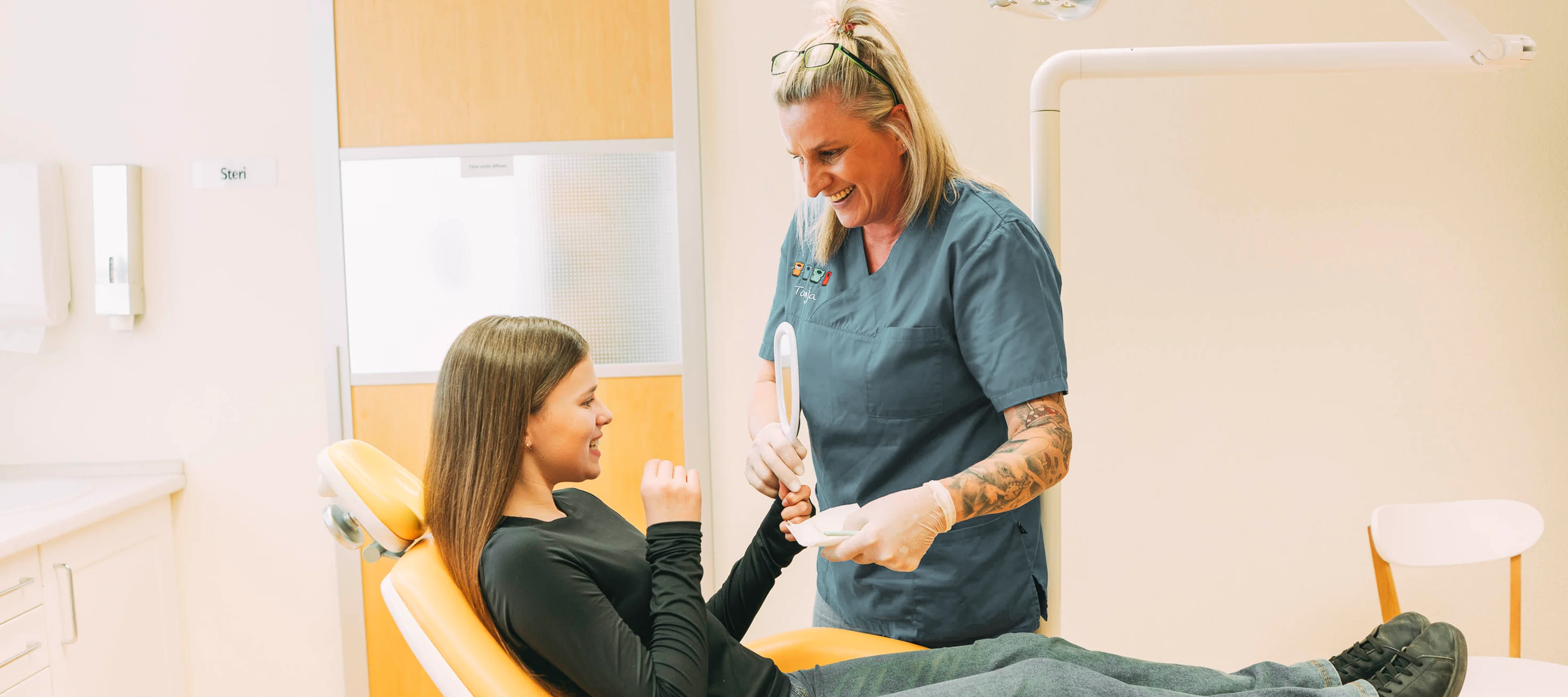 Kind schaut in den Spiegel und betrachtet die Ergebnisse einer Zahnbegradigung durch unsichtbare Zahnspange (Invisalign) in der Region Ludwigsburg